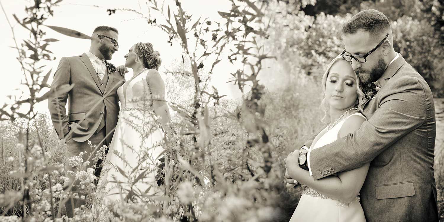 A black and white photo of a bride and groom standing in a field at The Lake House wedding photography by Connecticut Wedding Photographers Rogers Photography.