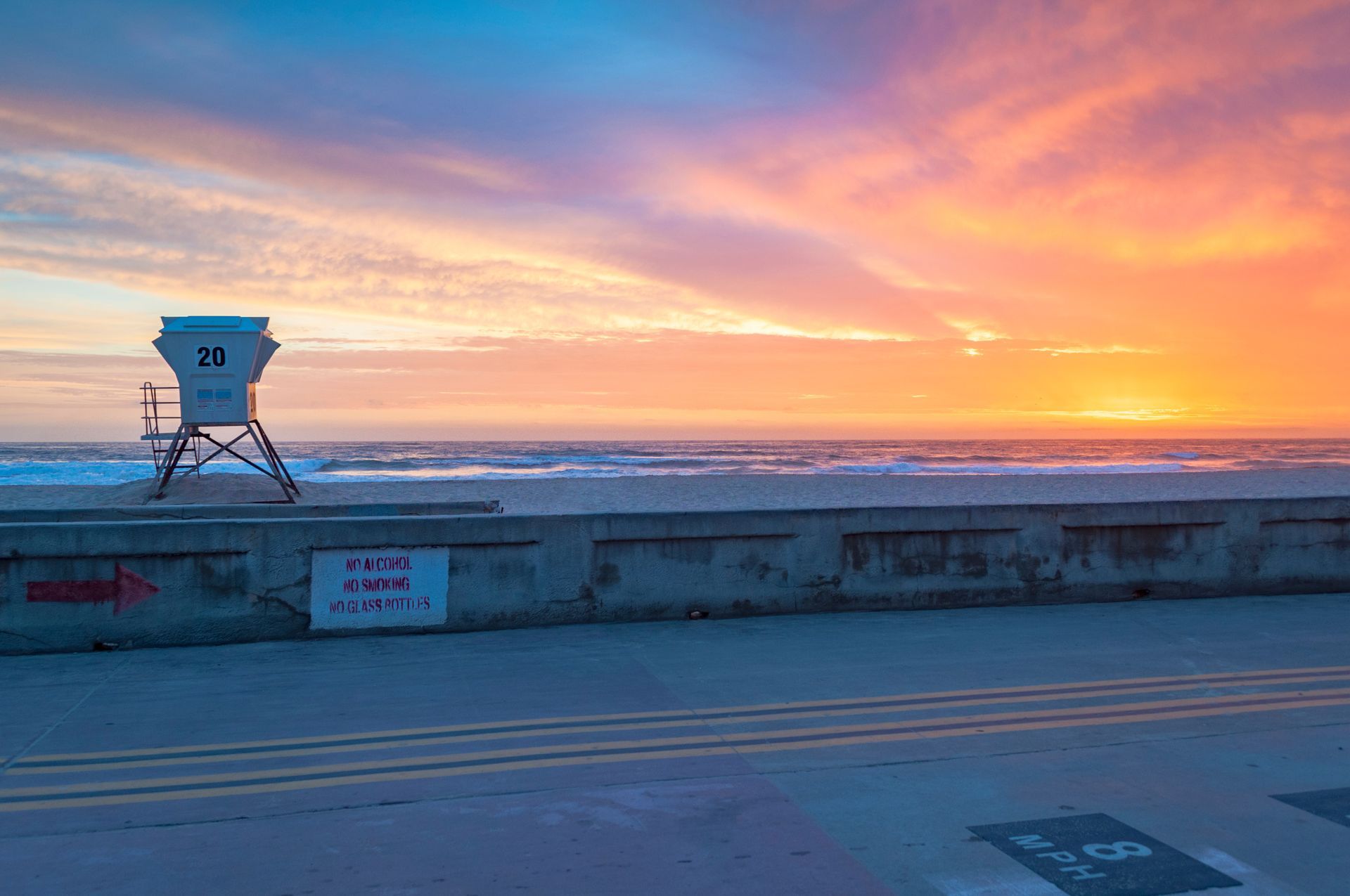 A lifeguard tower on the beach at sunset.