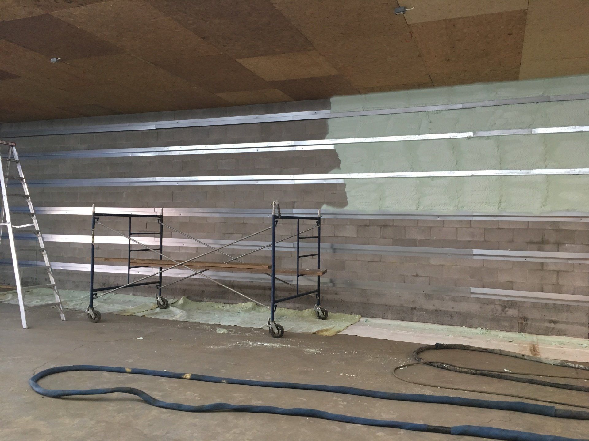 A room with a ladder and a hose in it