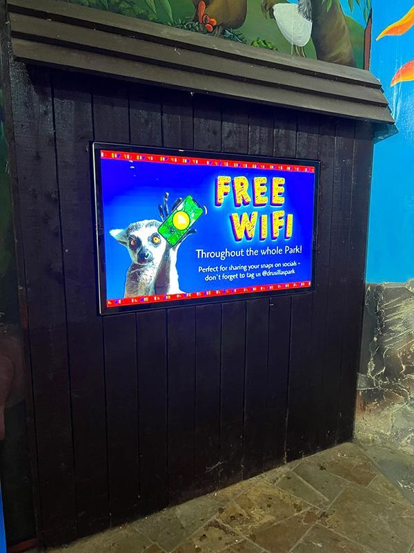 a digital sign on a wall that says free wifi