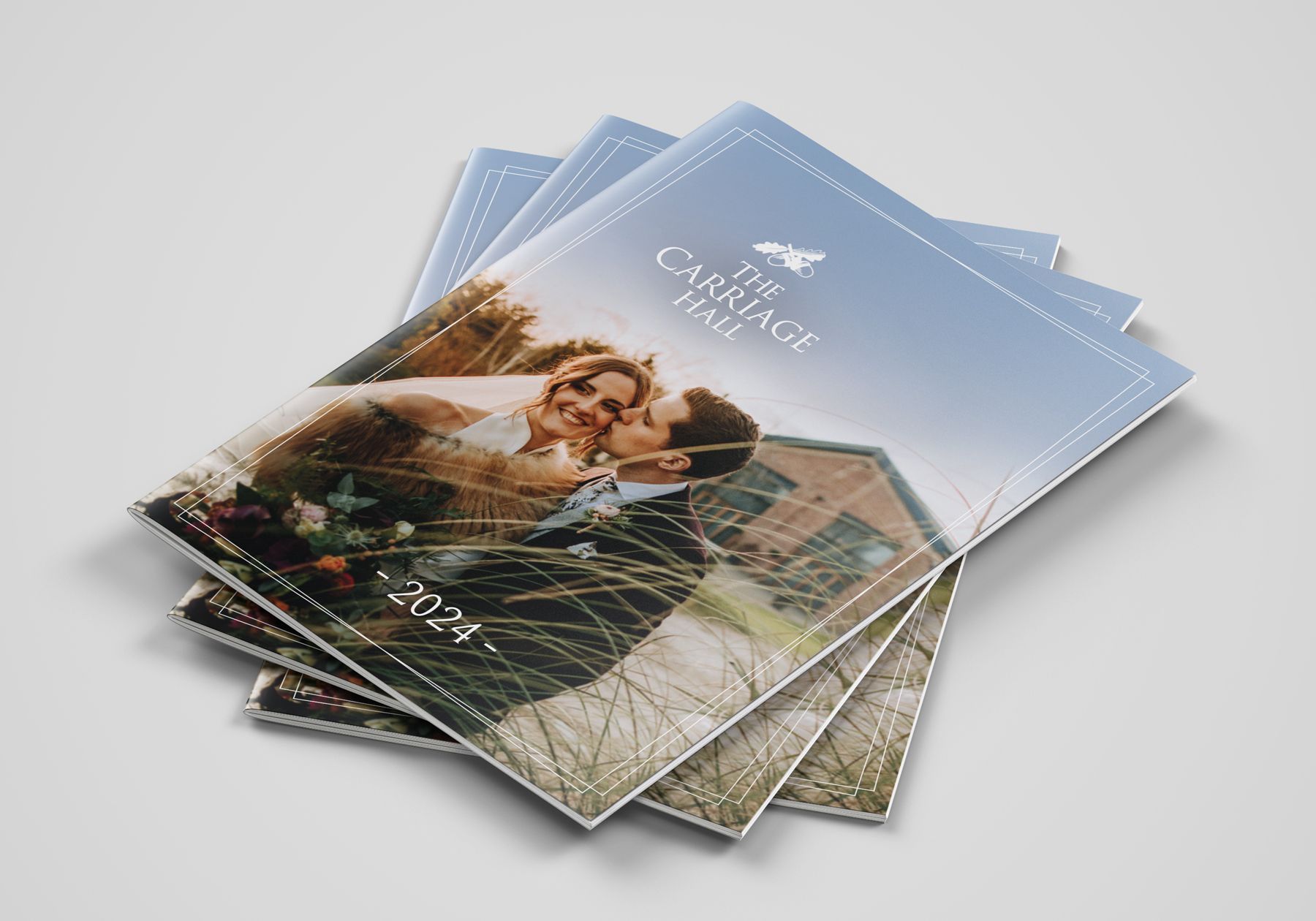 A stack of wedding brochures for Carriage Hall, includes a picture of a bride and groom on the cover.