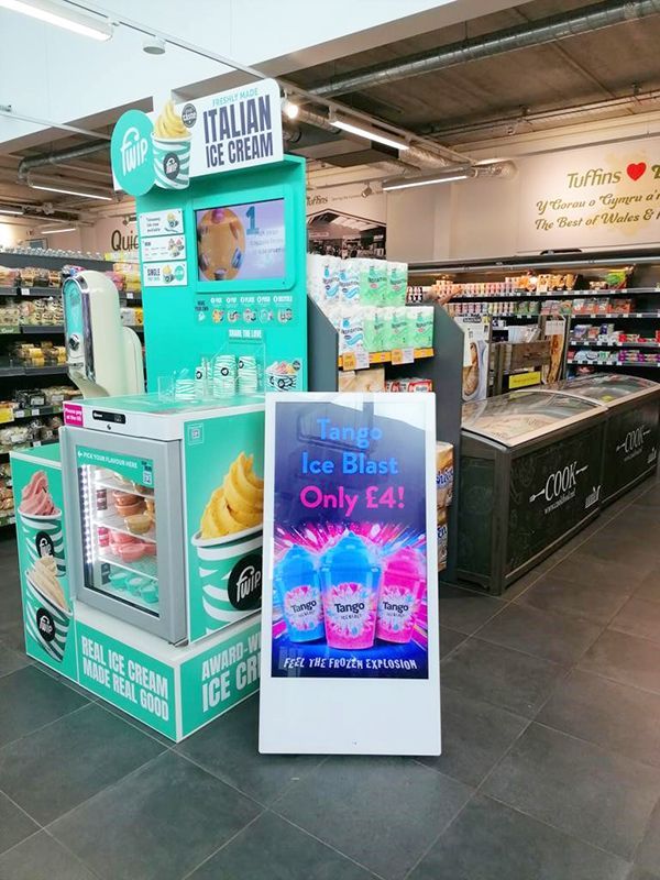 Display promoting Italian ice cream and Ice Blast drinks in a grocery store. Turquoise and white signage.