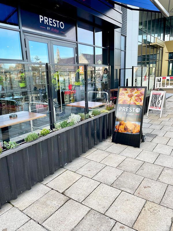 Presto Cafe exterior with outdoor seating, sign, and large windows.