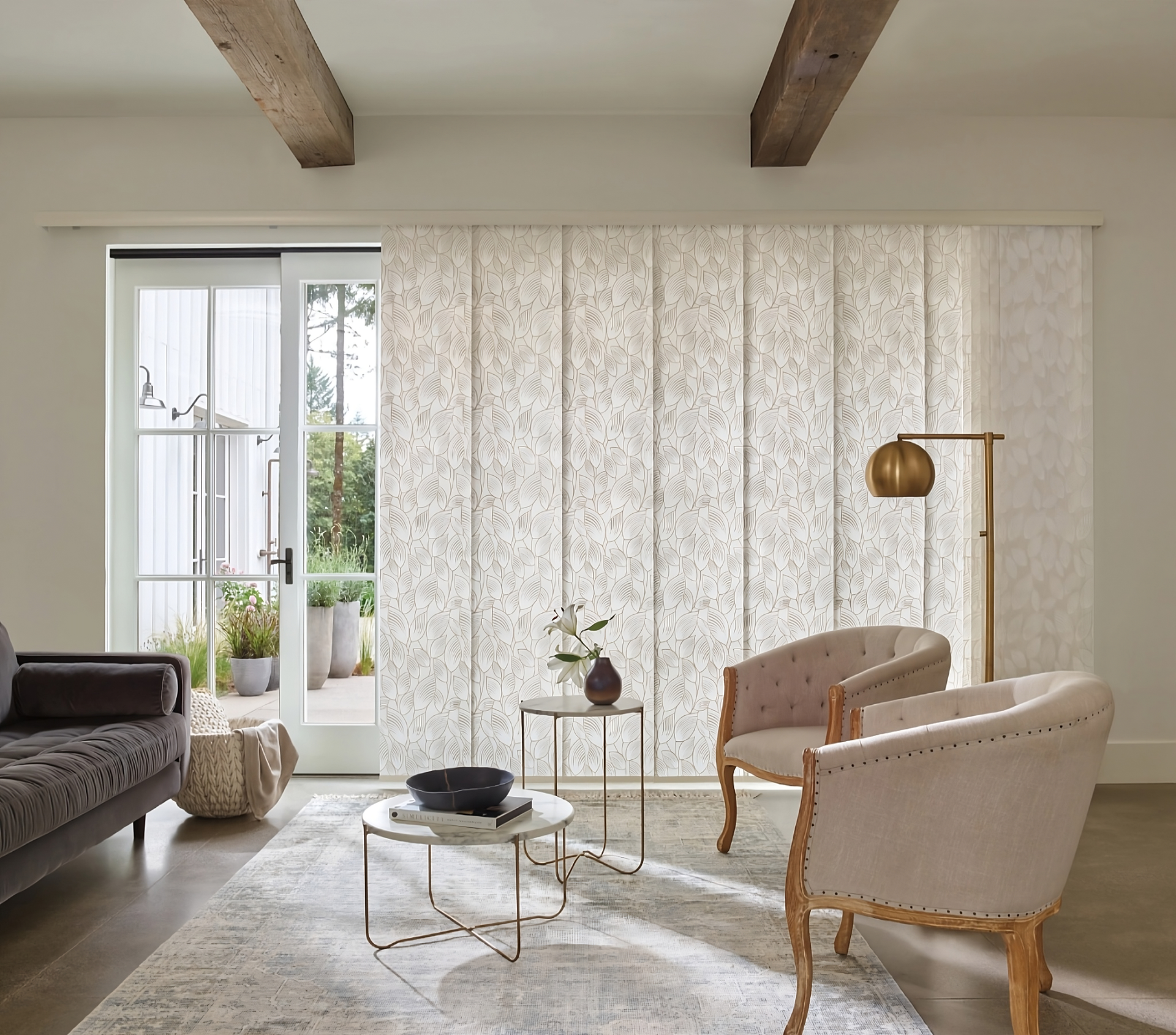 Skyline® Panel-Track Blinds with a botanical pattern on a sliding glass door in a living room