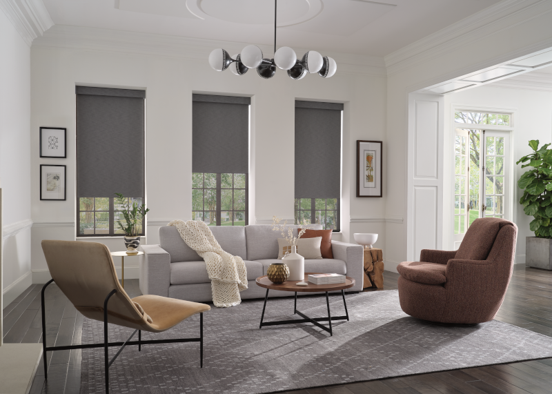 Hunter Douglas Designer Roller Shades on three windows, partially opened, in a chic living room