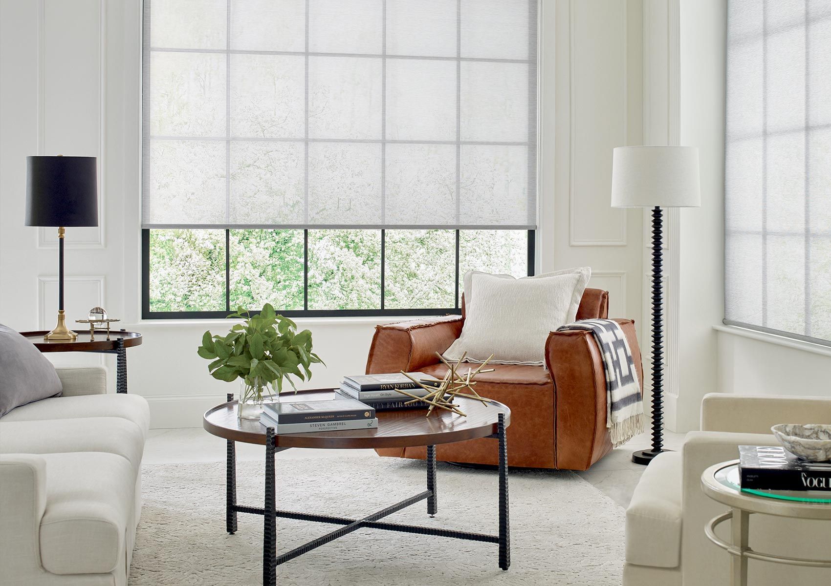 Hunter Douglas Designer Roller Shades in bright, modern living room with white and leather furniture