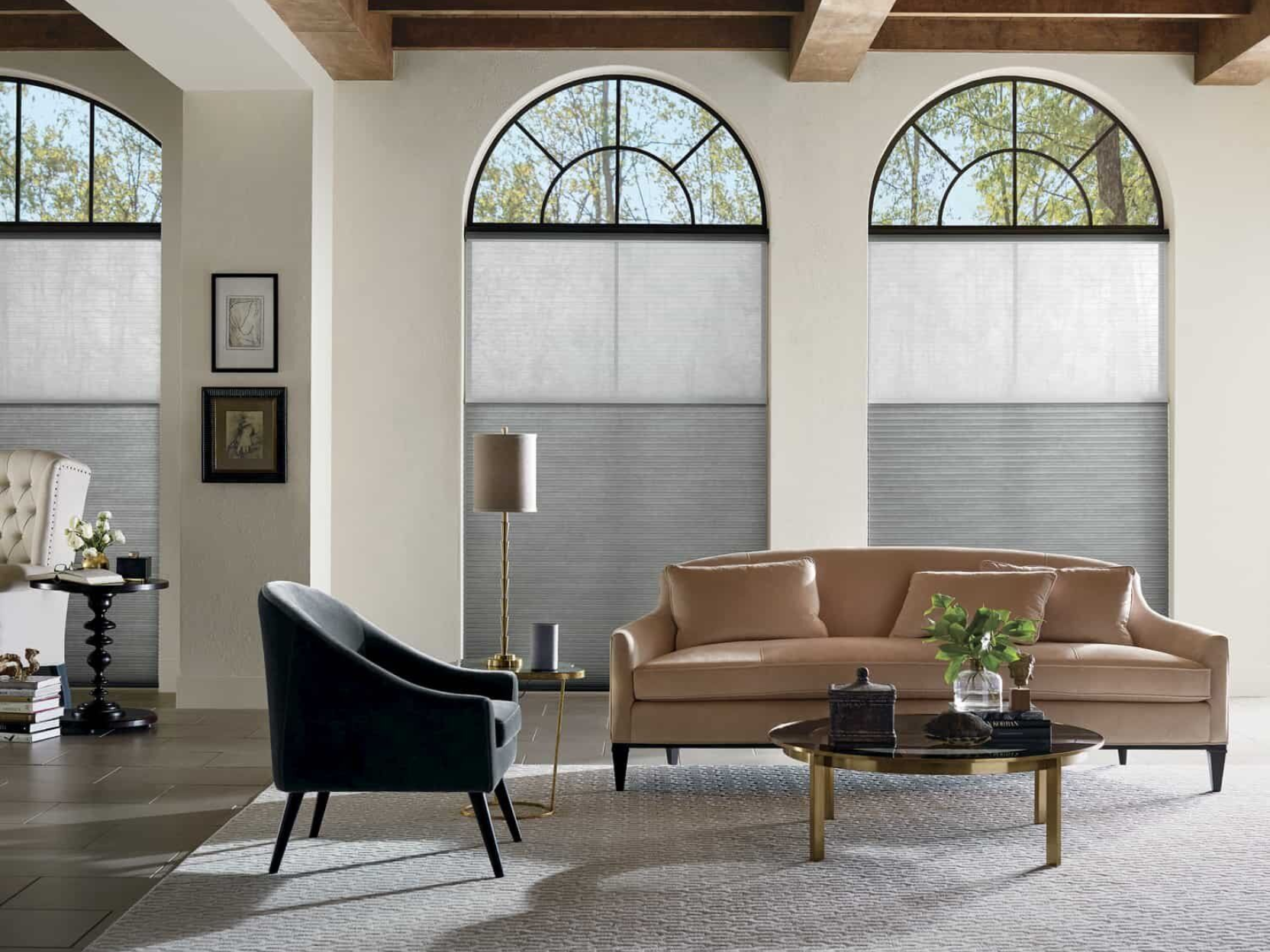 Living room with two large arched windows covered by Hunter Douglas Duette® Cellular Shades