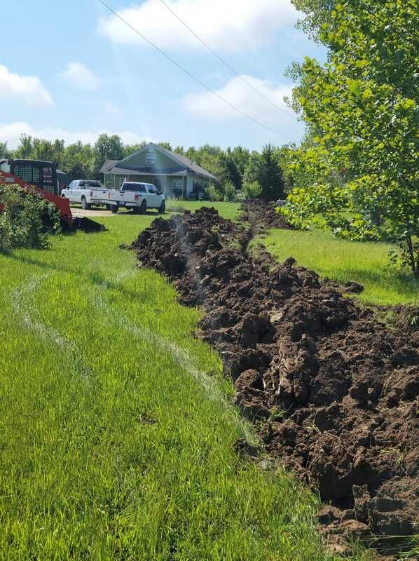 A large pile of dirt is in the middle of a grassy field.
