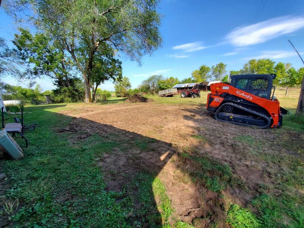 A bulldozer is sitting in the middle of a grassy field.