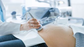 Una mujer embarazada se está haciendo una ecografía con un médico.