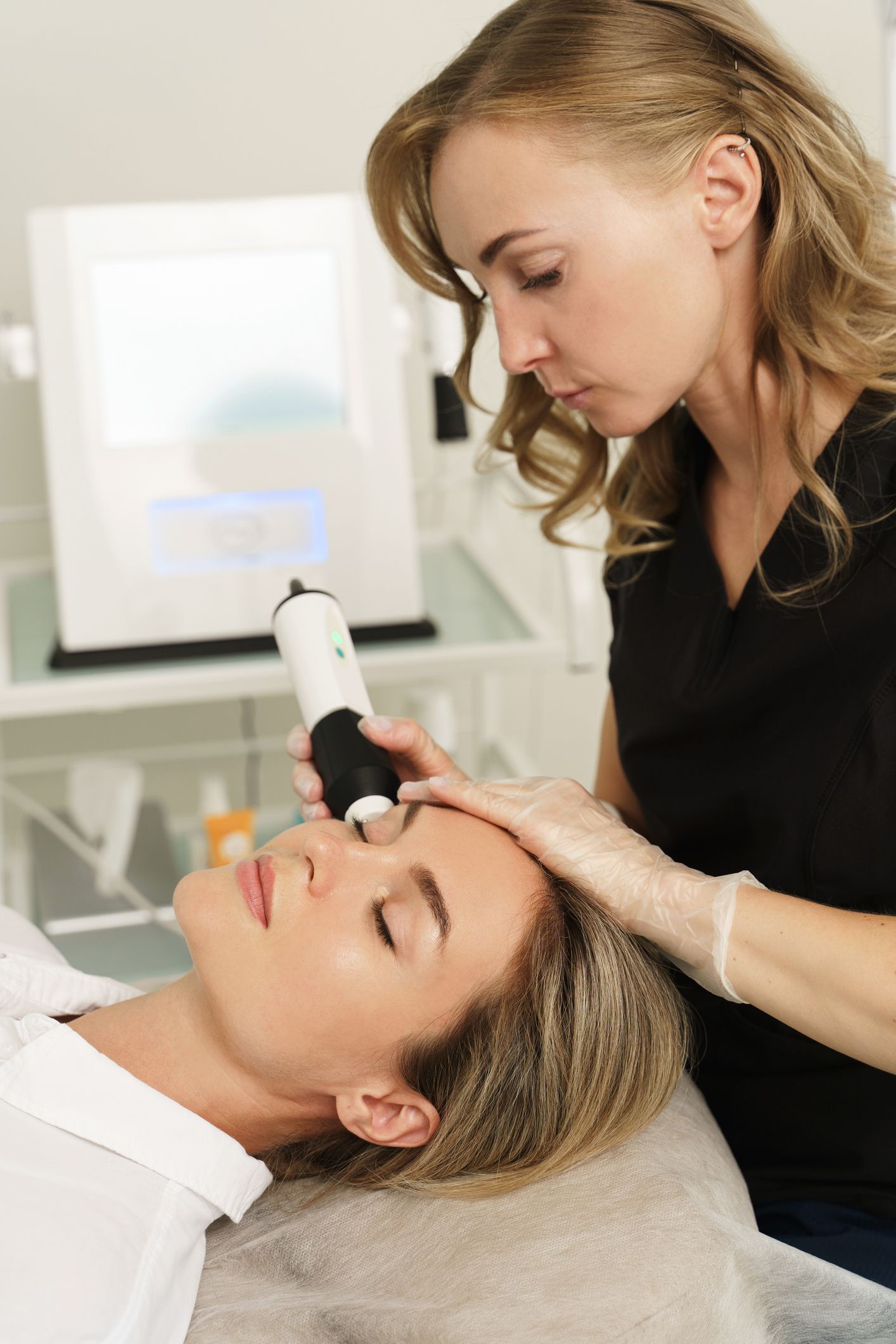 A woman is getting a facial treatment at a beauty salon.