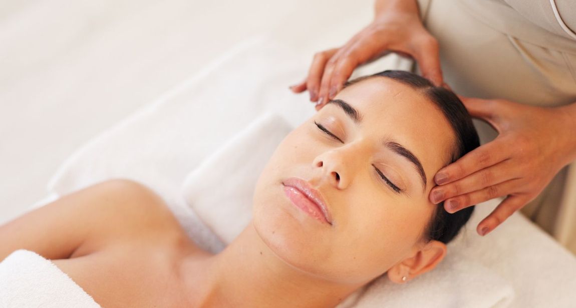 A woman is getting a head massage at a spa.