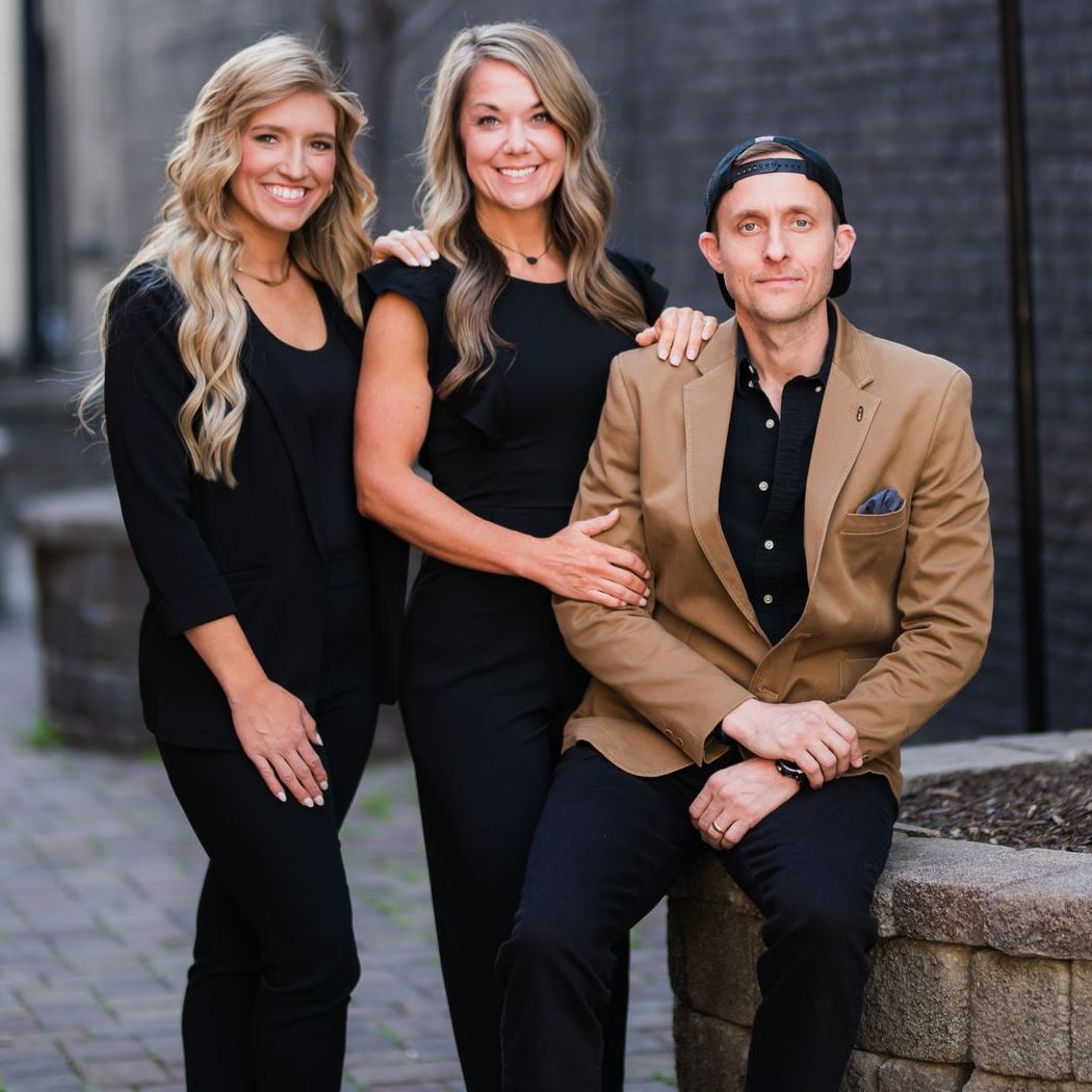 Two women and a man are posing for a picture