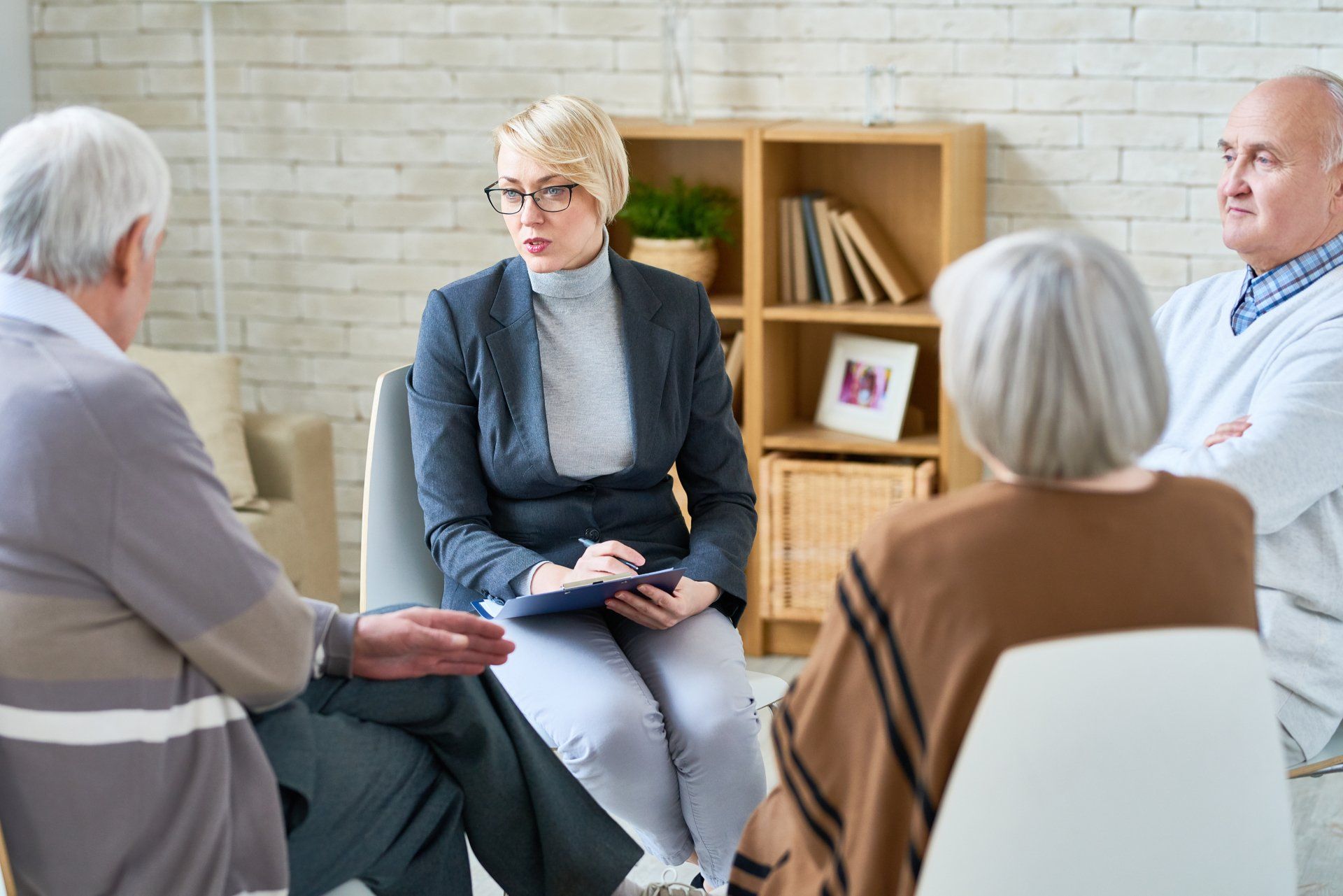 Female psycologist leading a group therapy session.