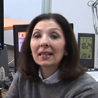 Una donna è seduta alla scrivania davanti al monitor di un computer.