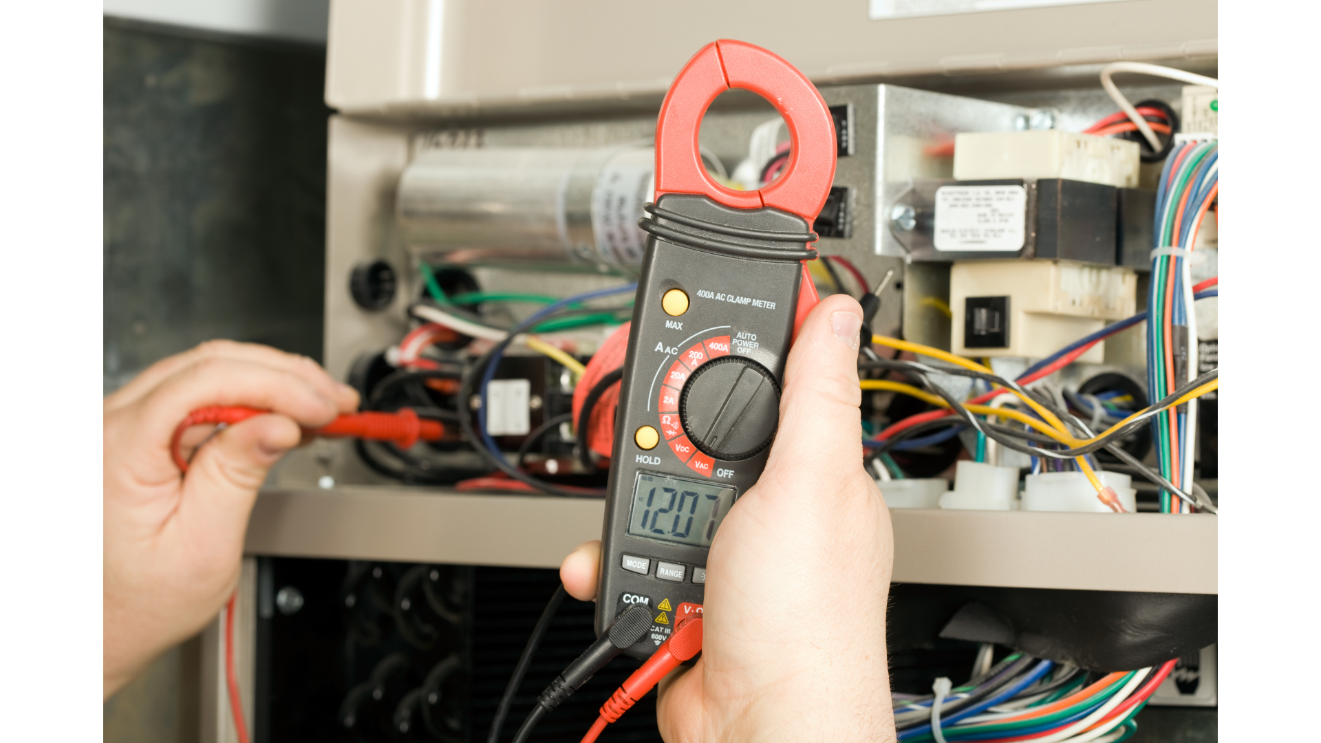 A person is using a clamp meter to check a heater.