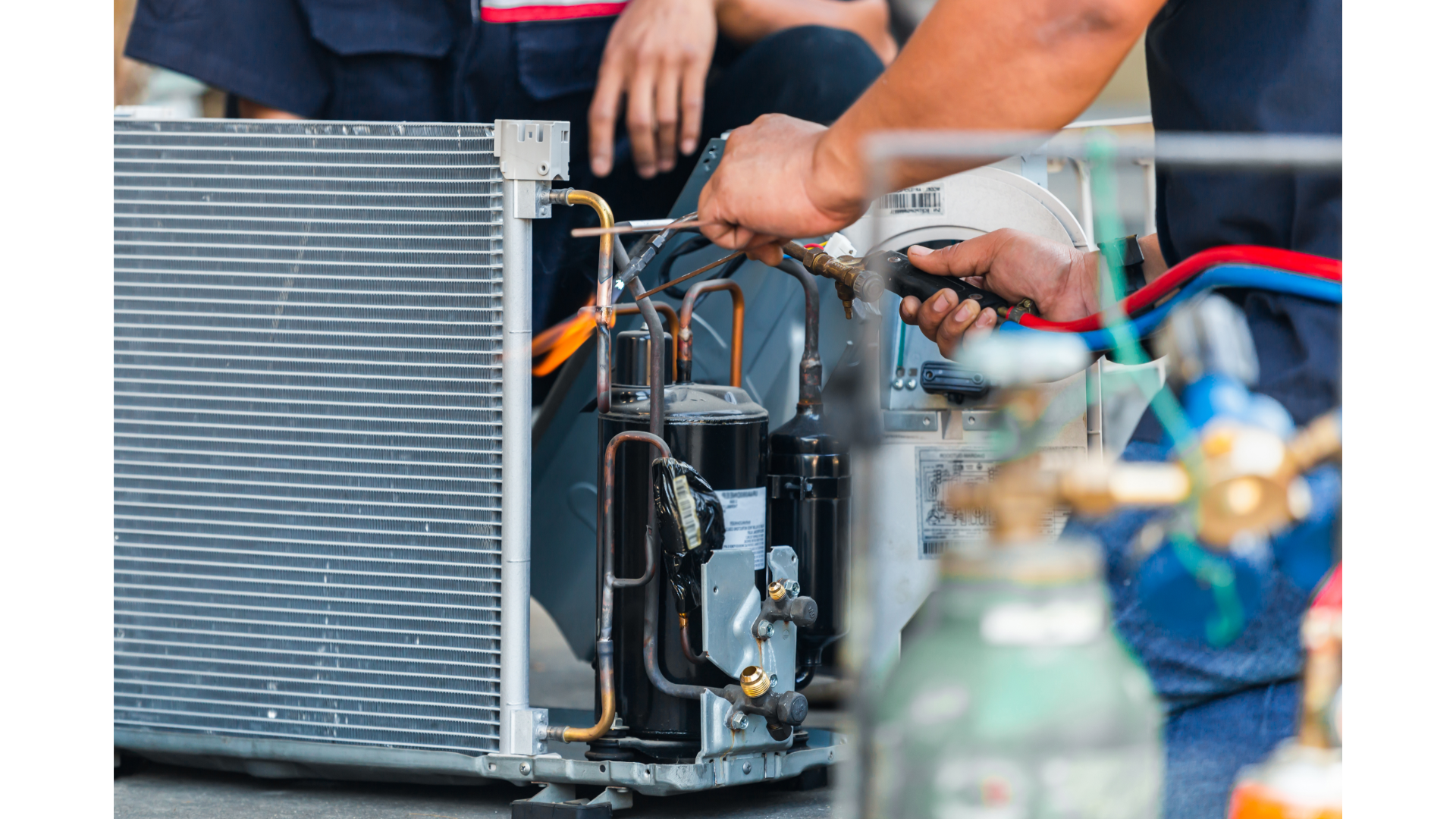 A man is working on a refrigerator with a screwdriver.