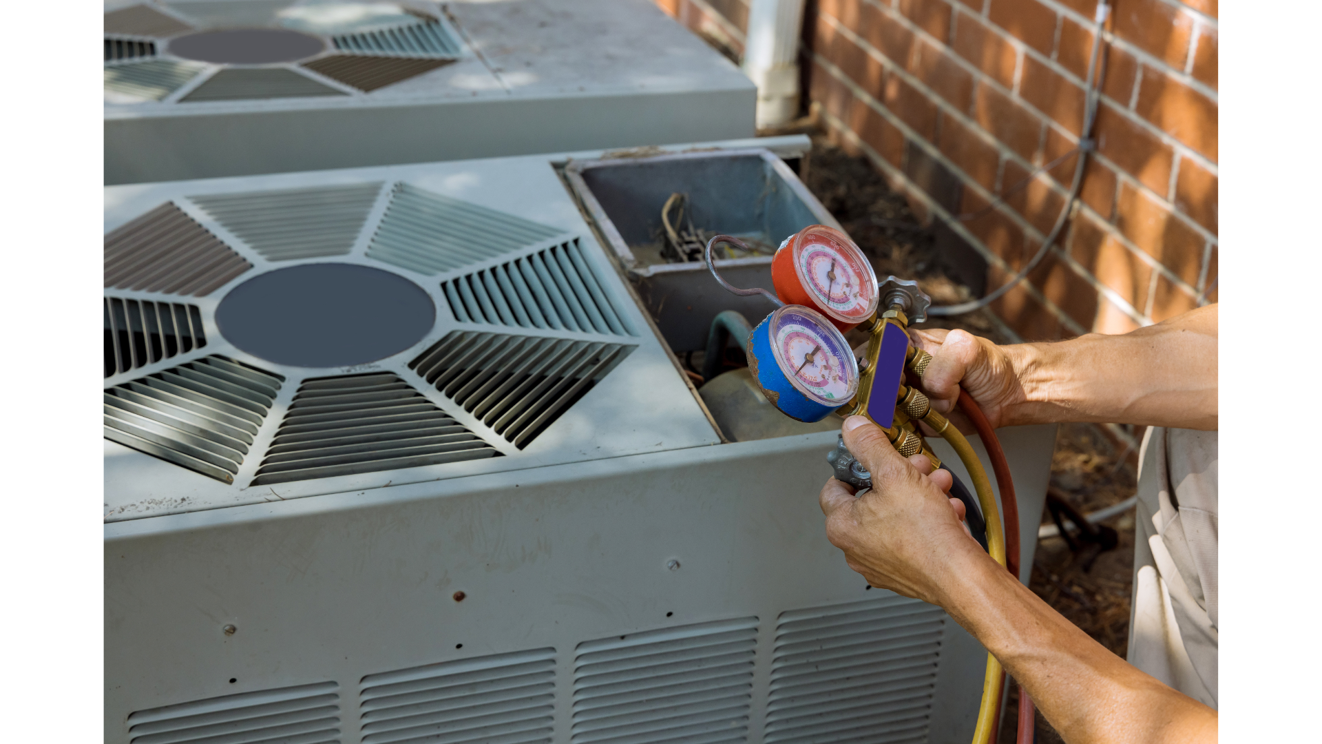 A man is working on an air conditioner outside of a brick building.