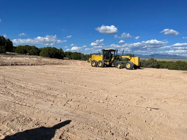A yellow bulldozer is sitting in the middle of a dirt field. A yellow bulldozer is sitting in the middle of a dirt field.