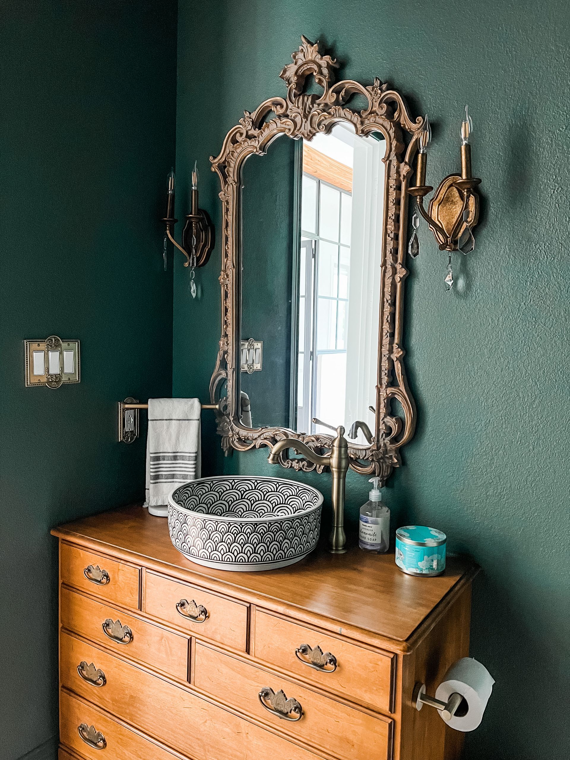 A bathroom with a sink , mirror and dresser.