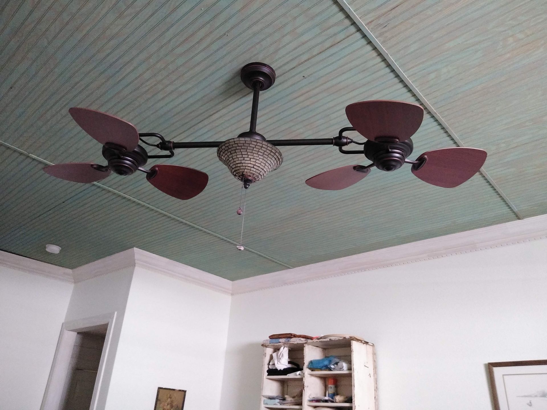 A ceiling fan is hanging from the ceiling of a room.