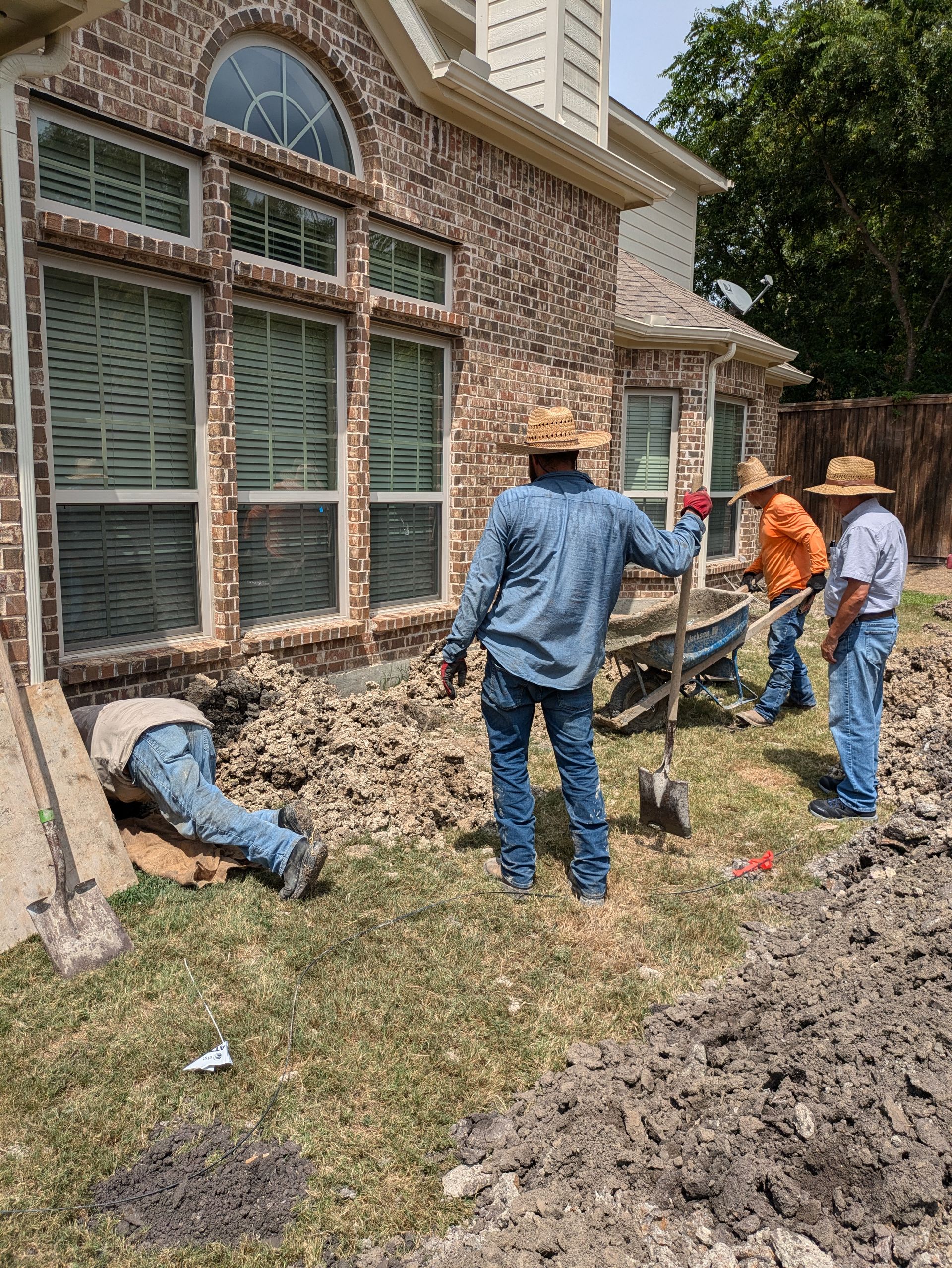 A group of men are working on the side of a house.