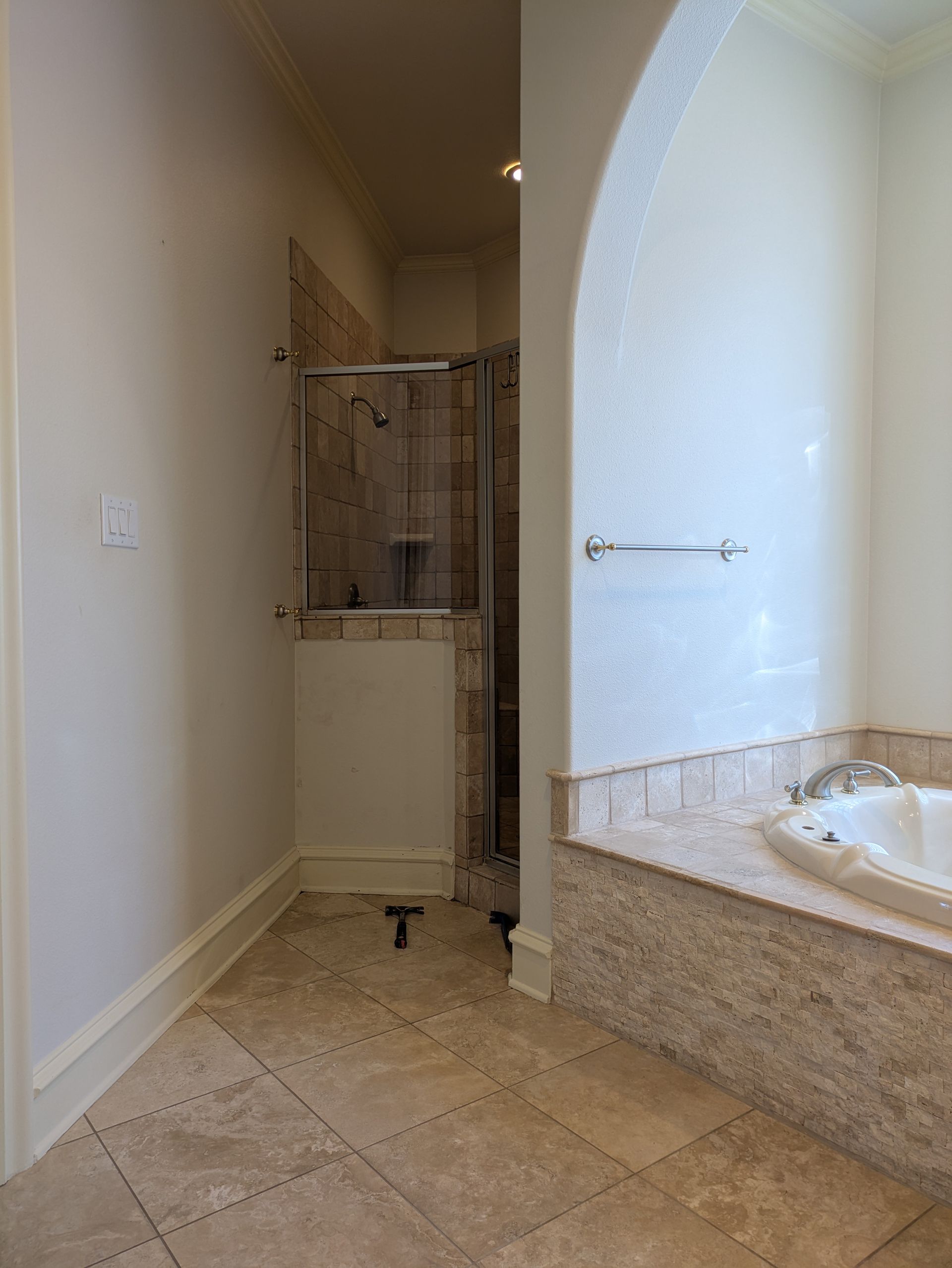 Bathroom with shower, tub, and beige tile floor and walls.