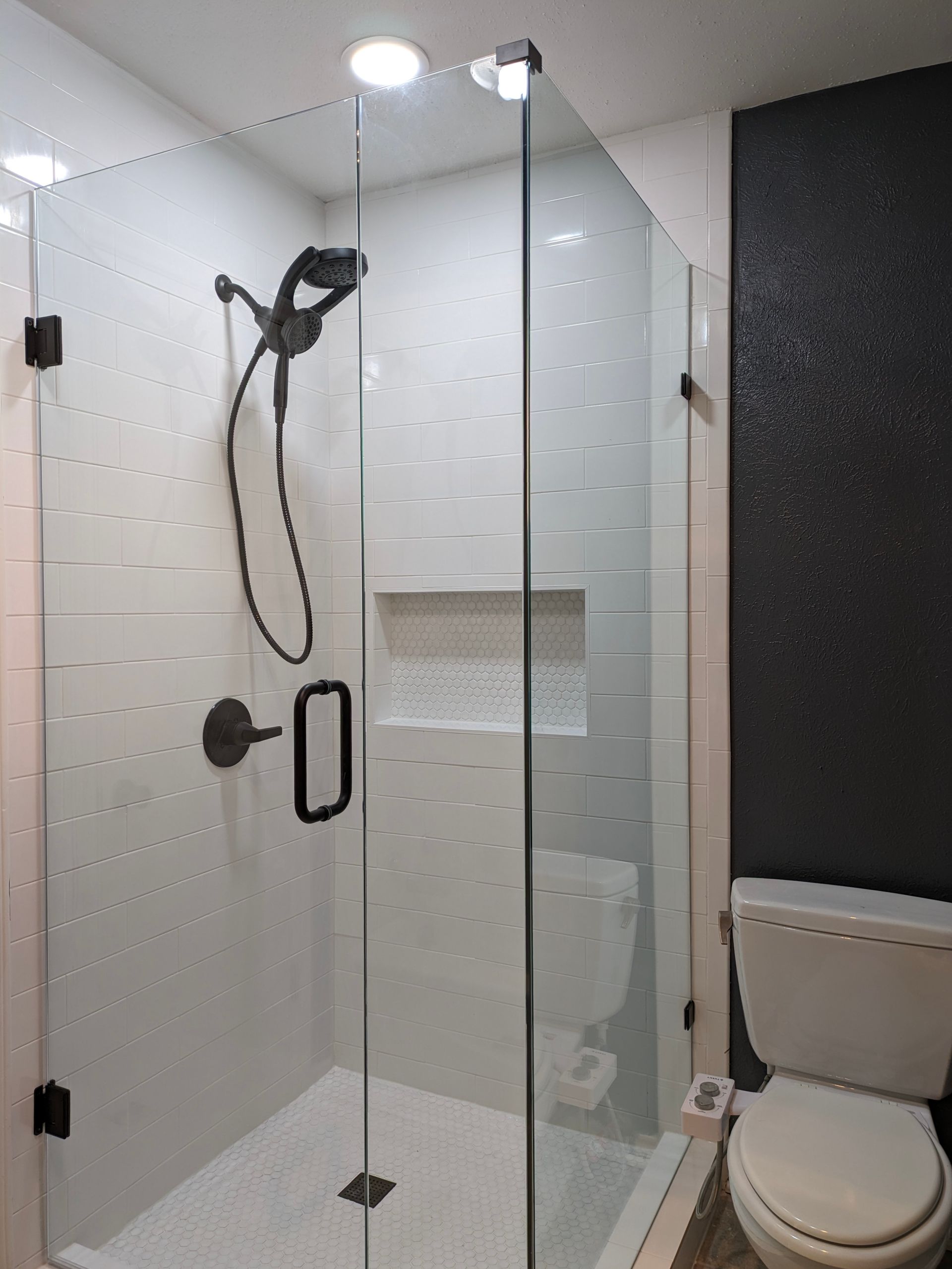 A bathroom with a walk in shower and a toilet.