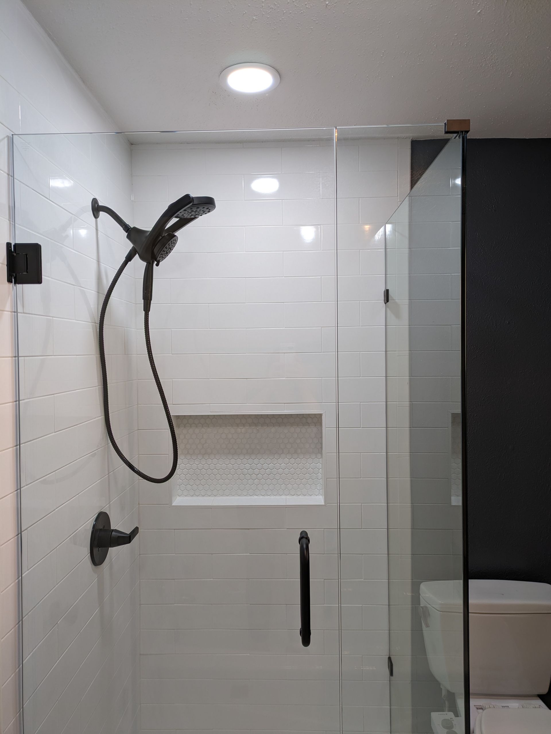 A bathroom with a shower head and a toilet.
