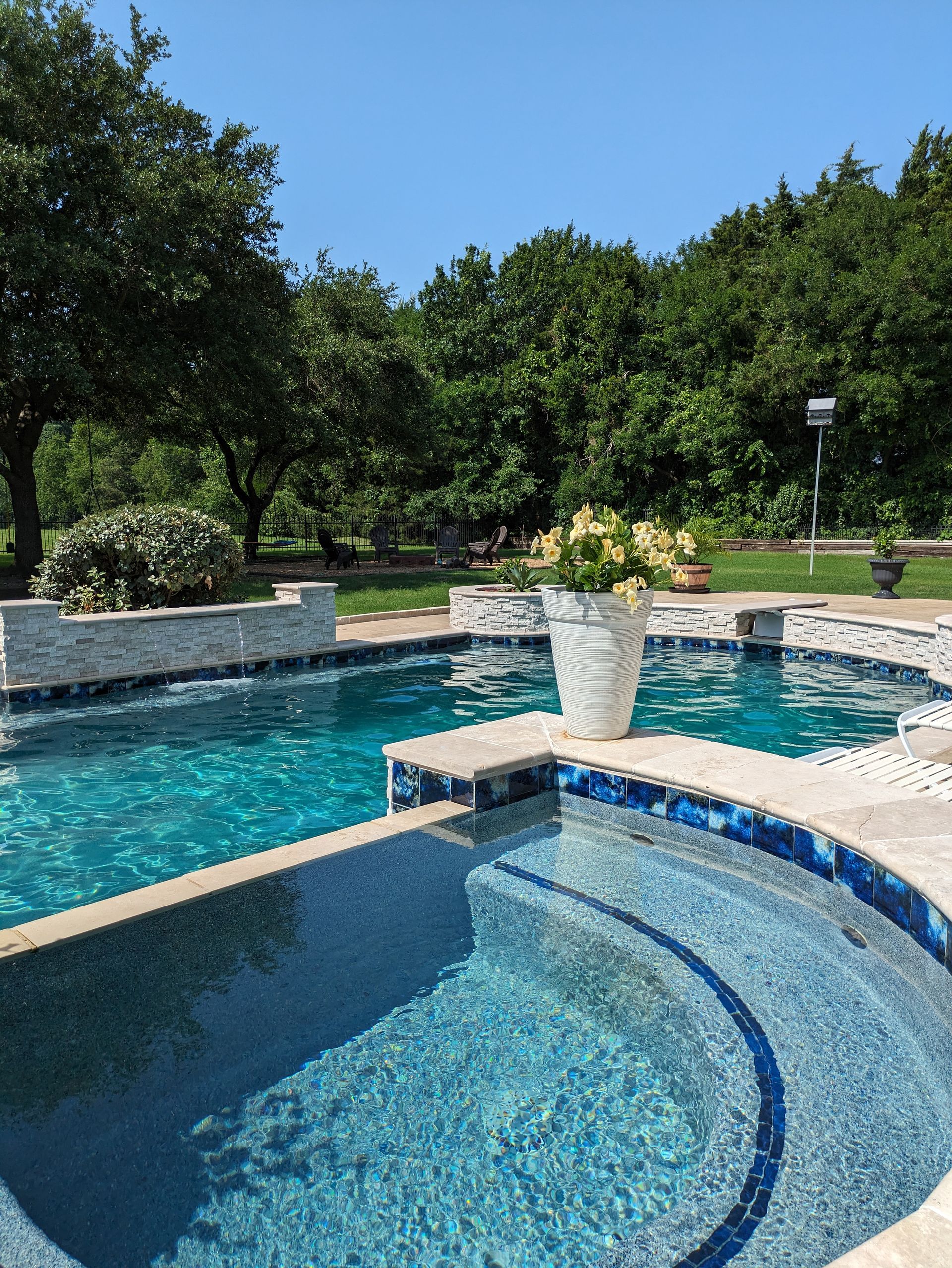A large swimming pool with a potted plant in the middle of it.