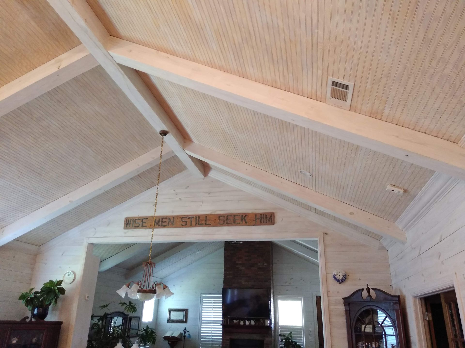 A living room with a vaulted ceiling and a sign that says 