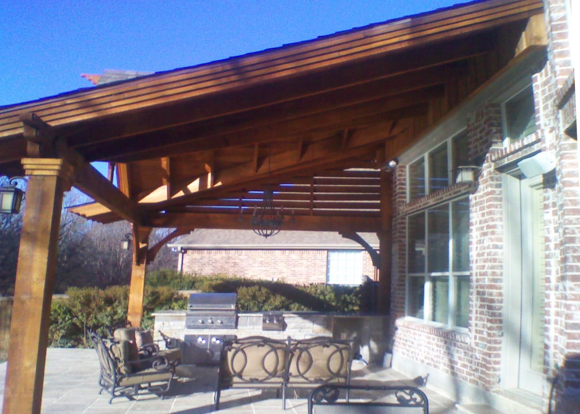 A brick house with a wooden pergola over it