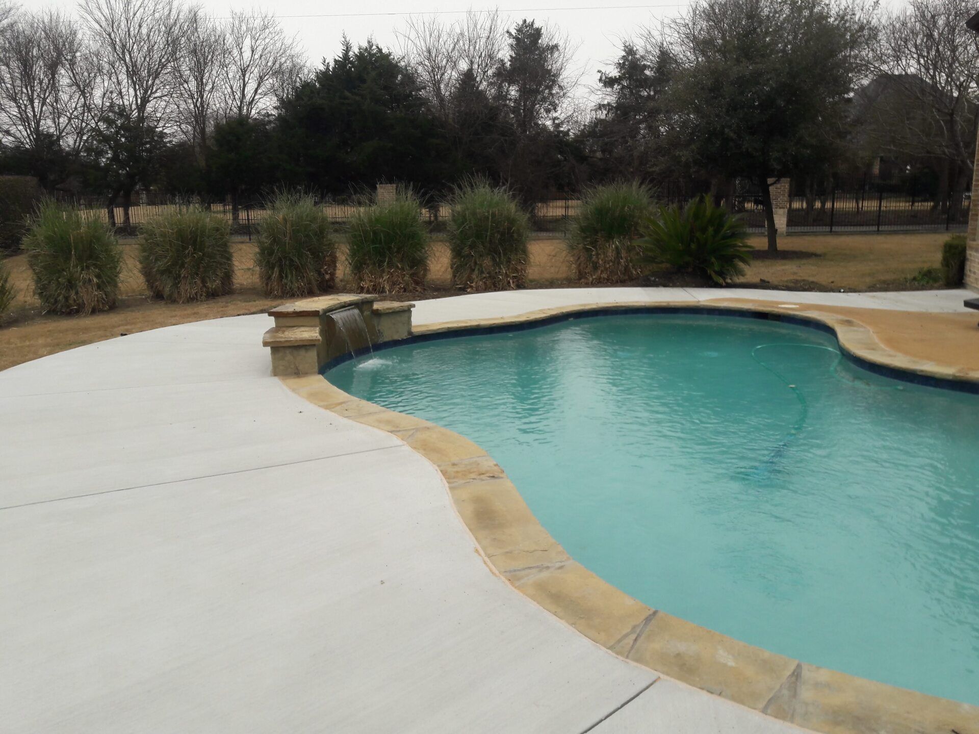 A large swimming pool with a waterfall in the middle of it