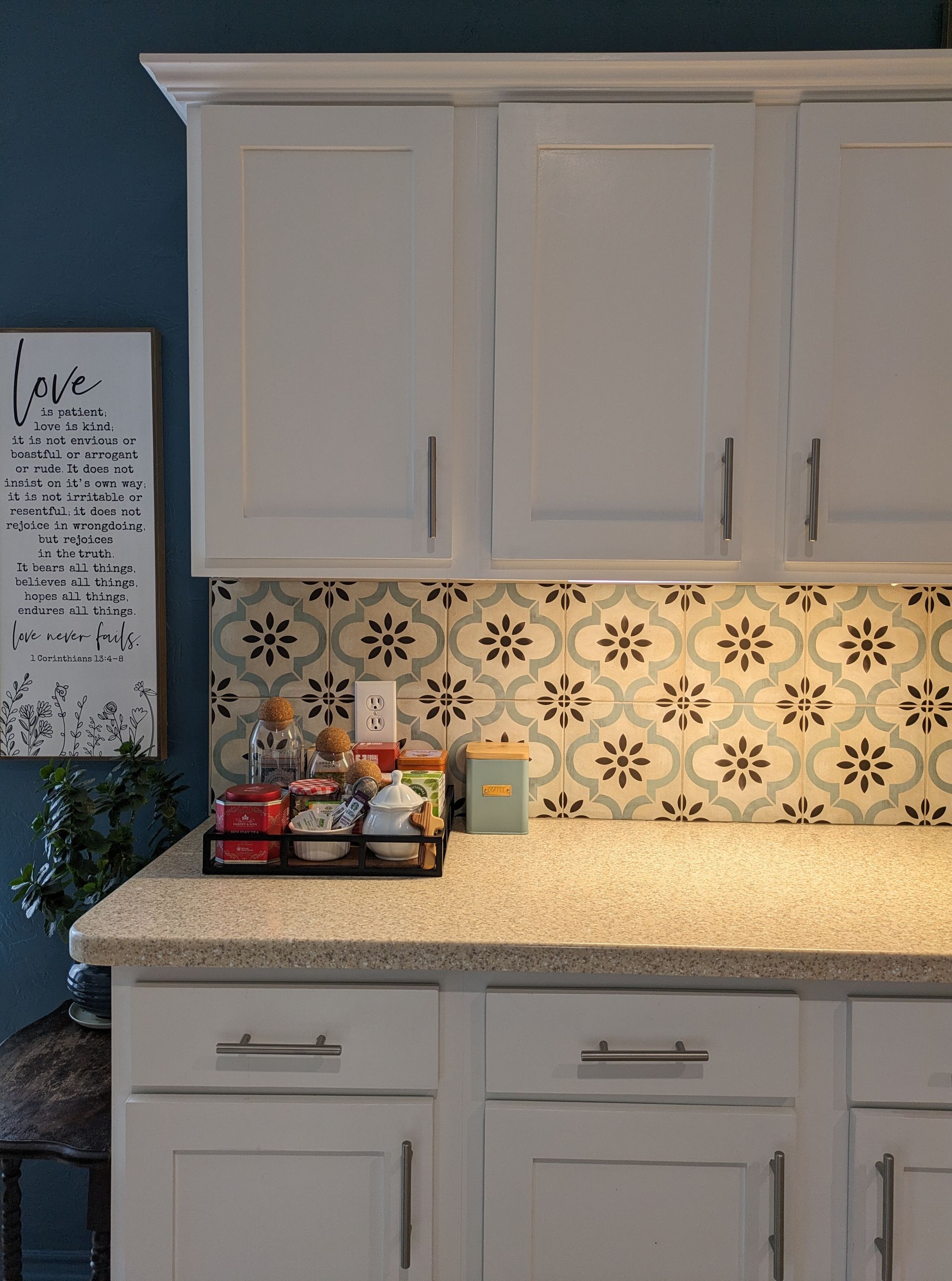 A kitchen with white cabinets and granite counter tops.