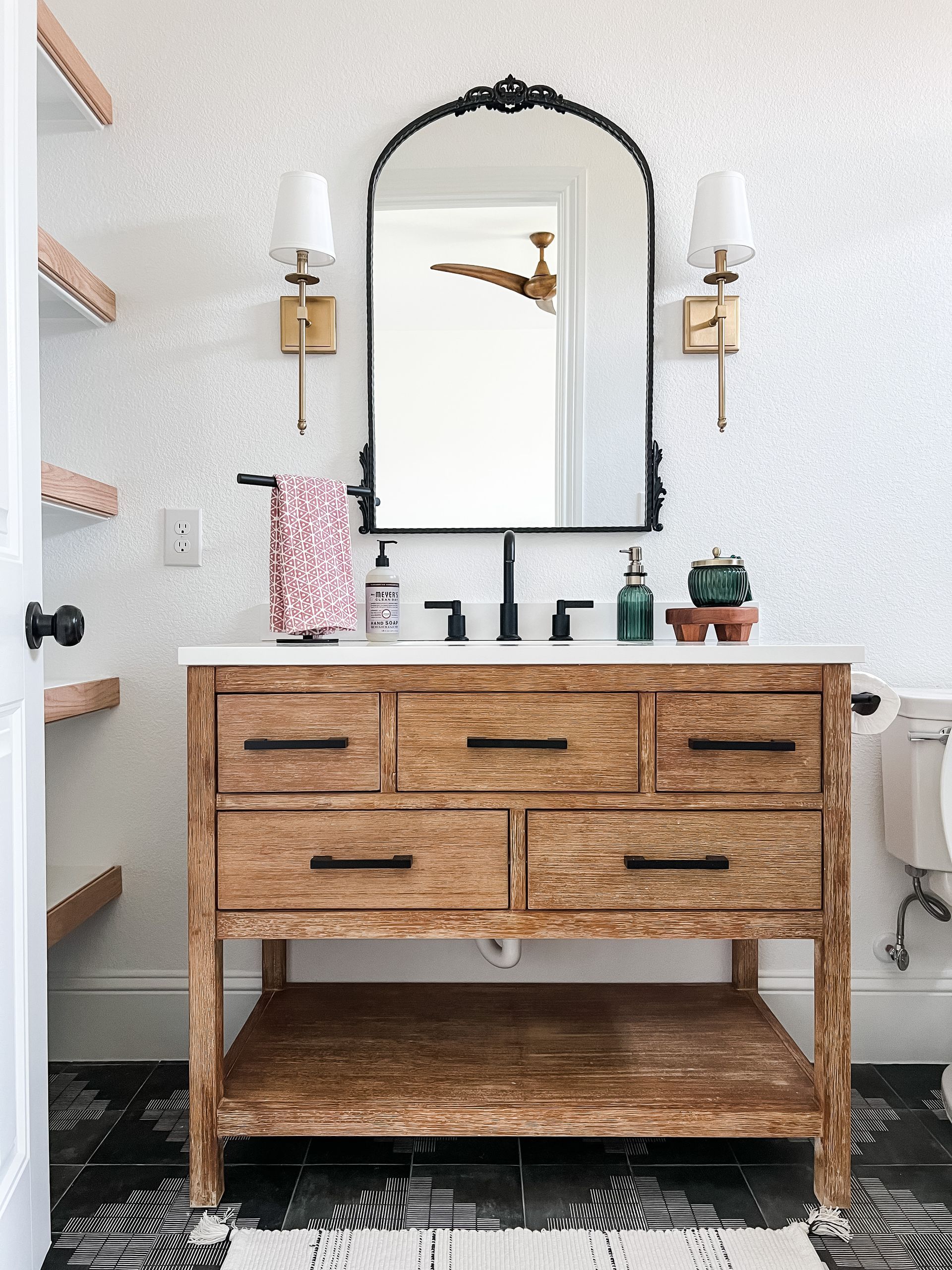A bathroom with a wooden vanity and a mirror