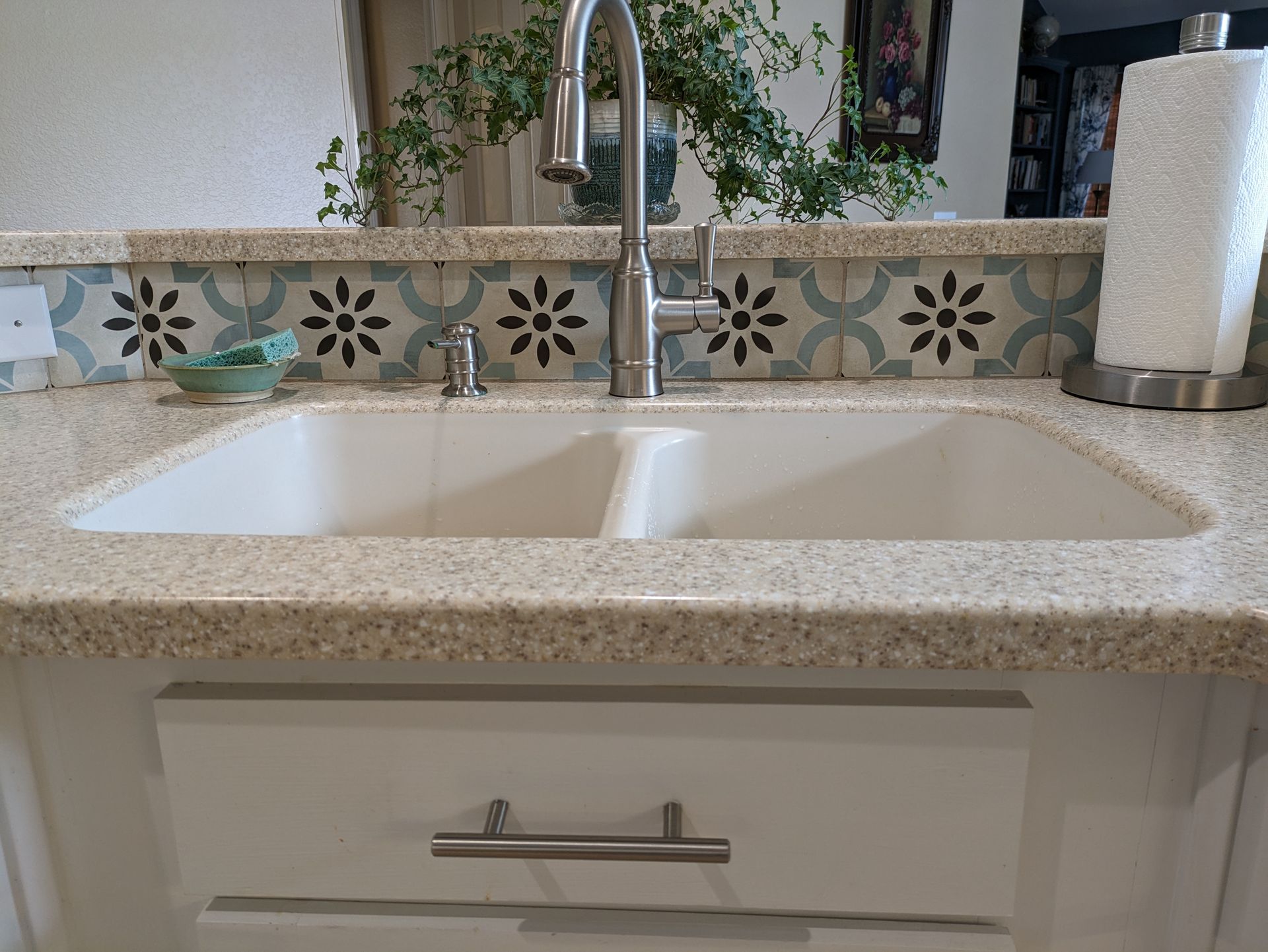A kitchen sink with a faucet and a paper towel holder.