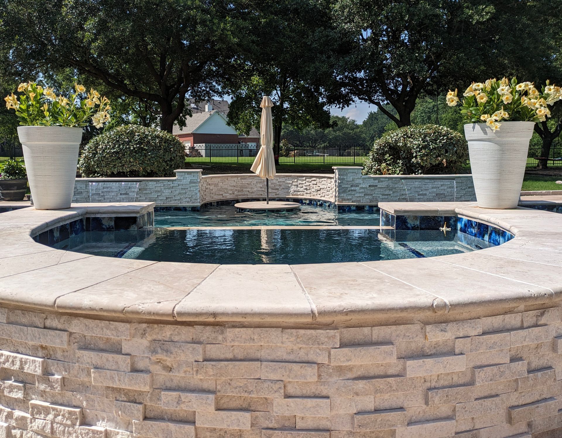 A swimming pool with a fountain in the middle of it