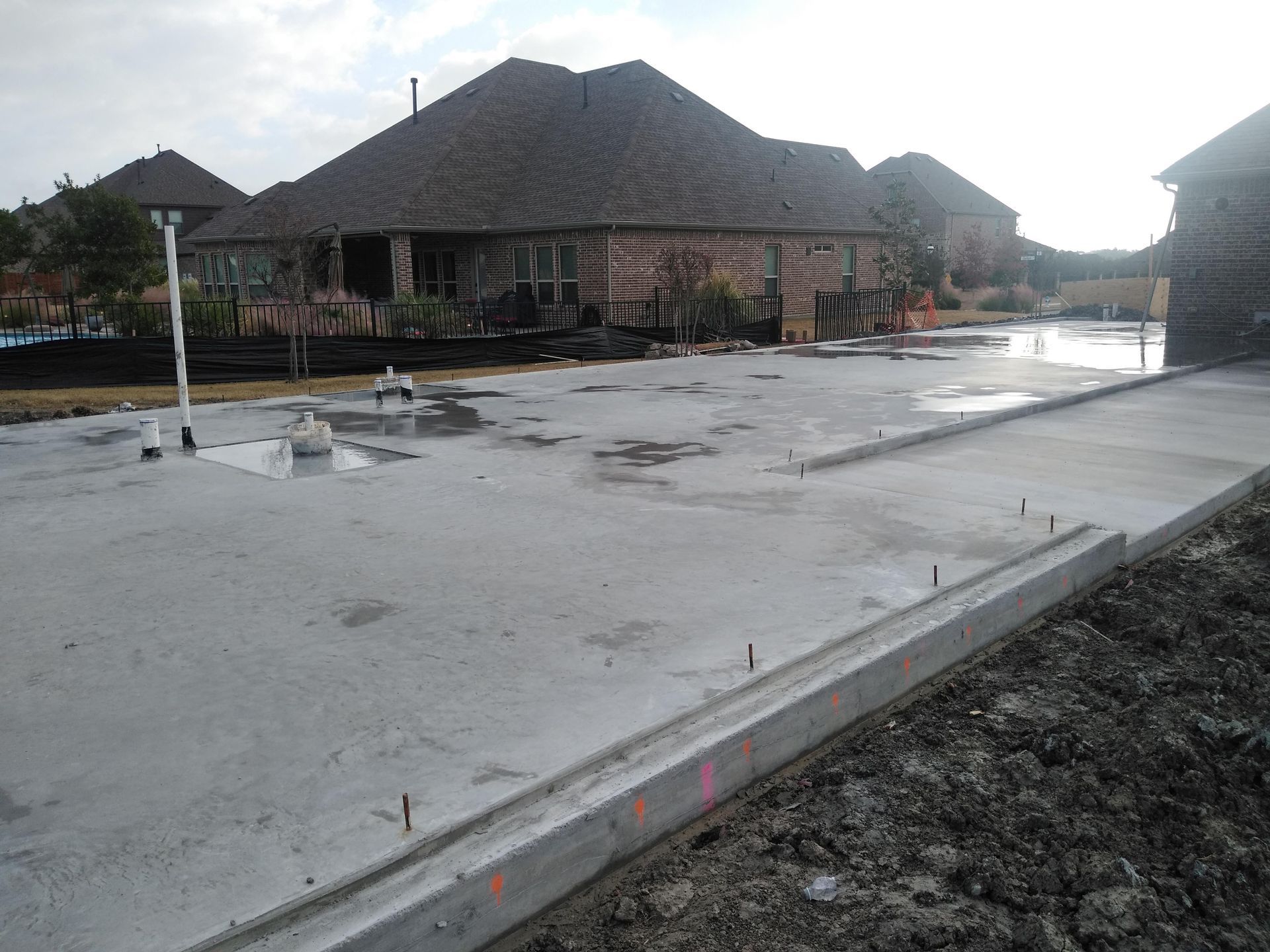 A concrete driveway is being built in front of a house.