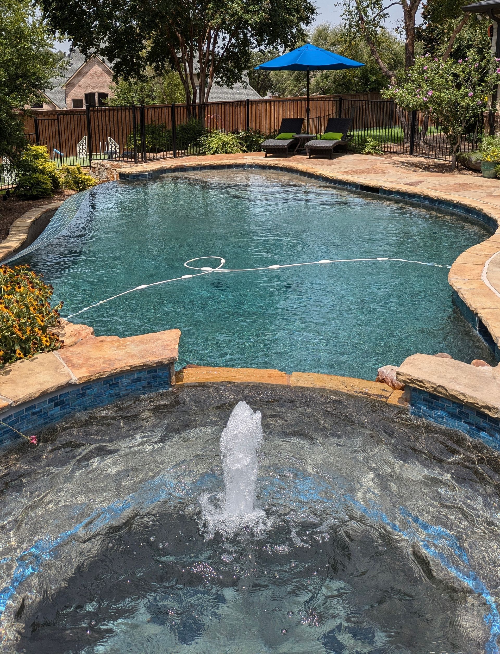 A large swimming pool with a fountain in the middle of it.