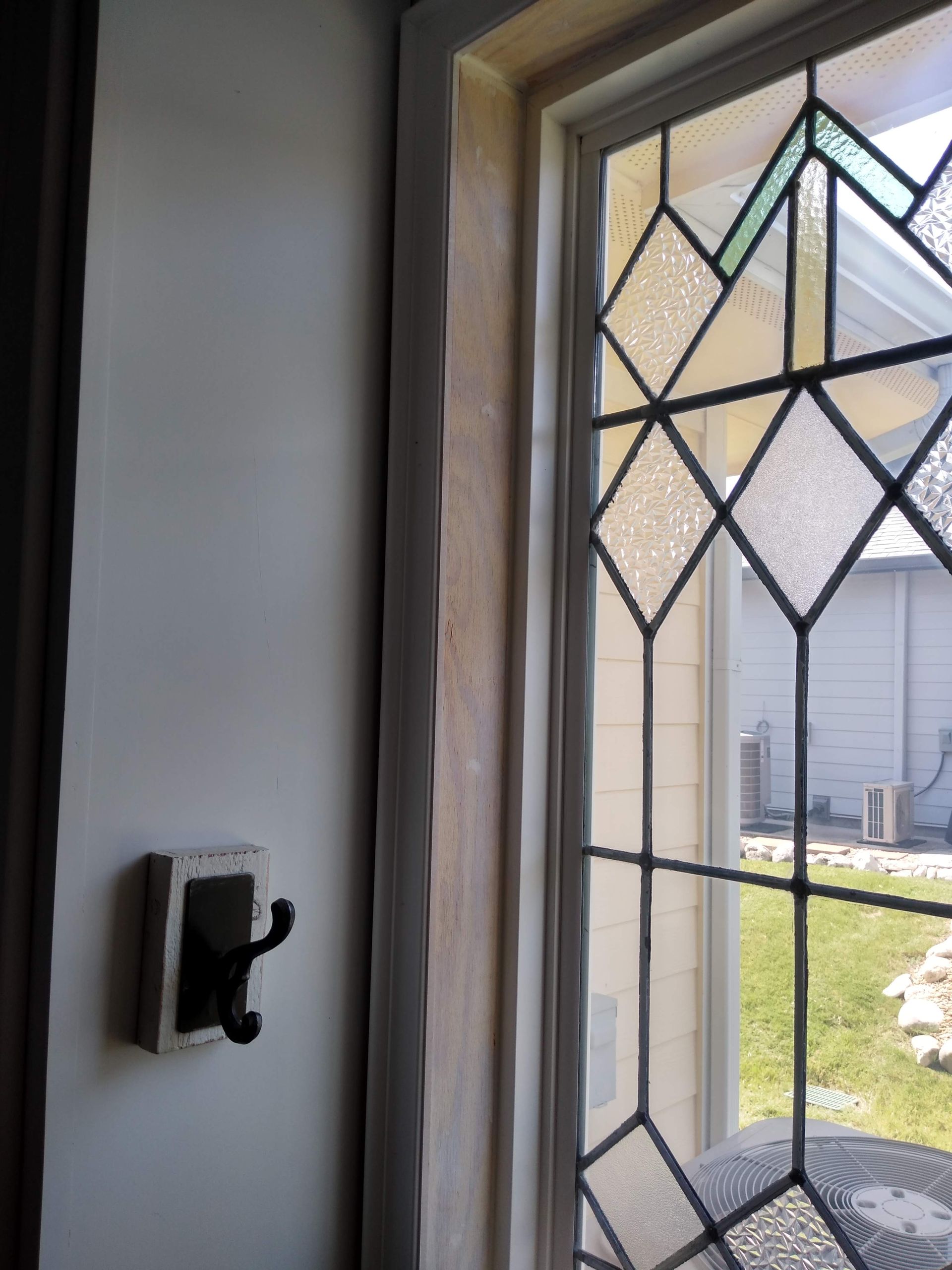 A stained glass window with a hook on the wall