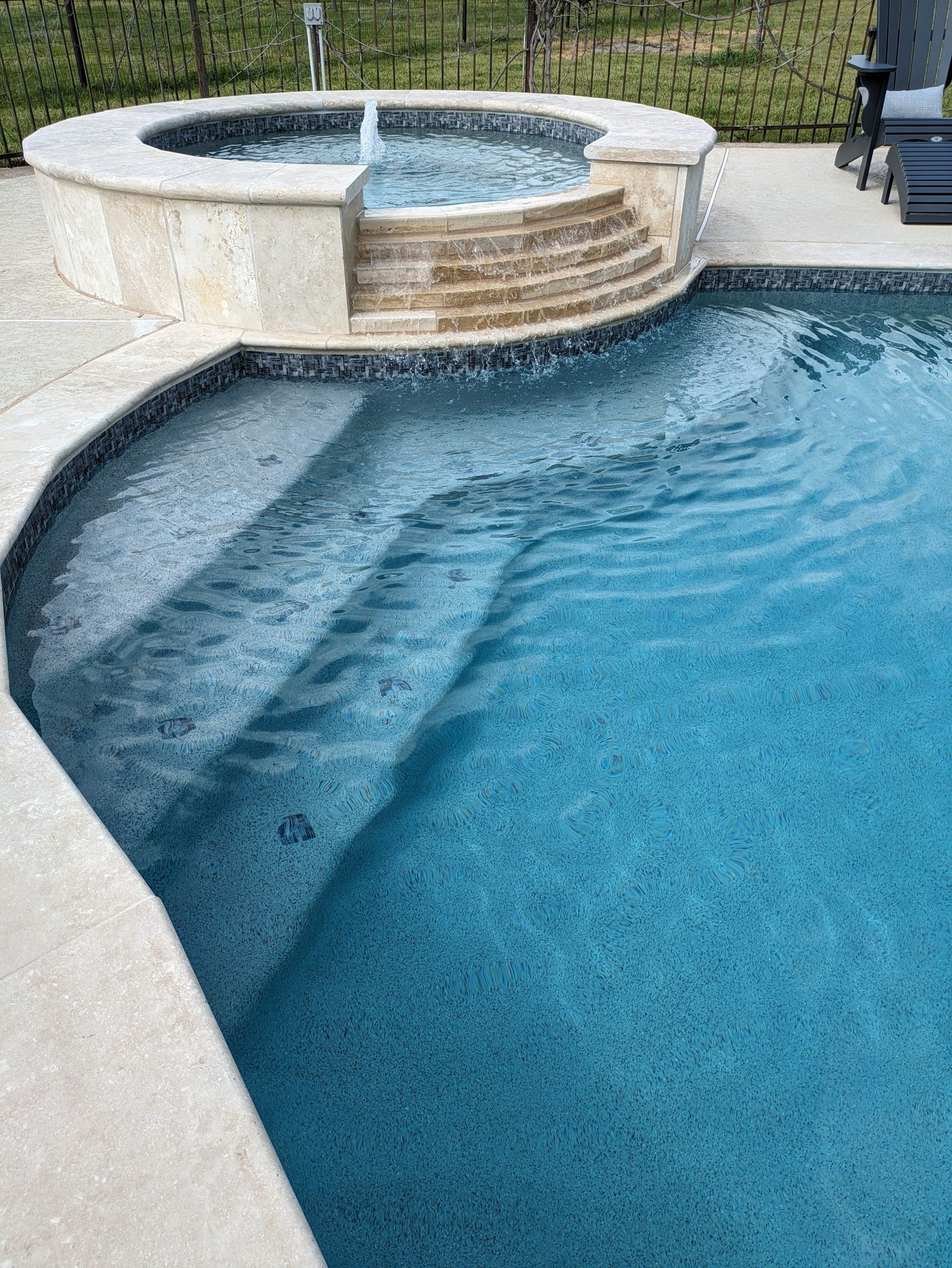 There is a hot tub in the middle of the pool.