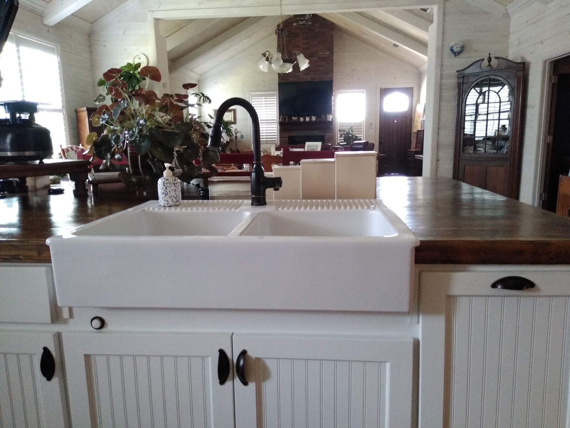 A kitchen with a white sink and a black faucet