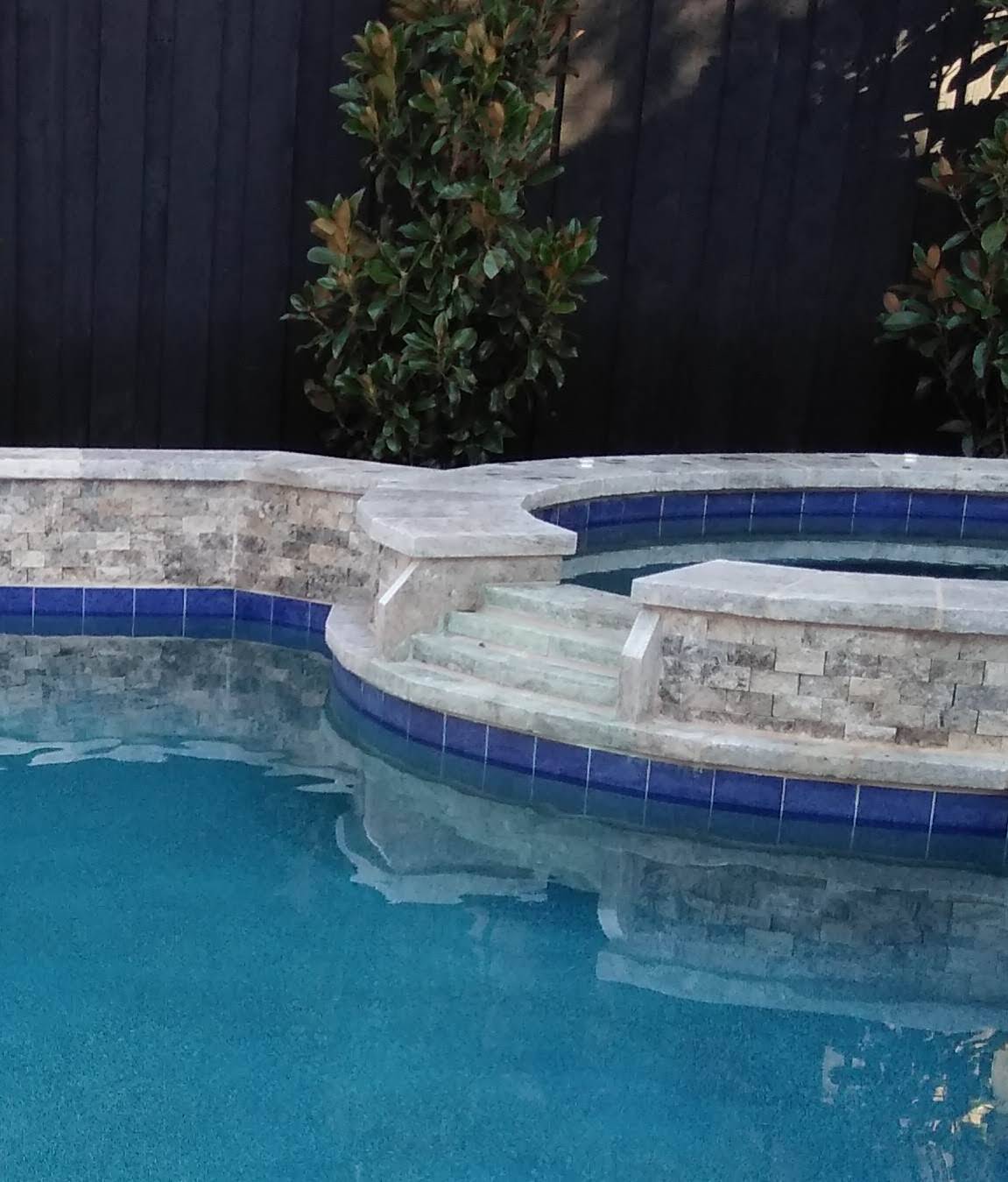 A swimming pool with a stone wall surrounding it