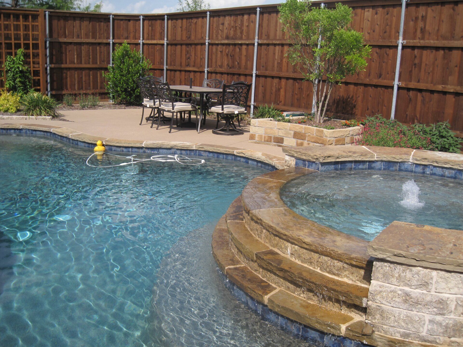 A swimming pool with a table and chairs next to it