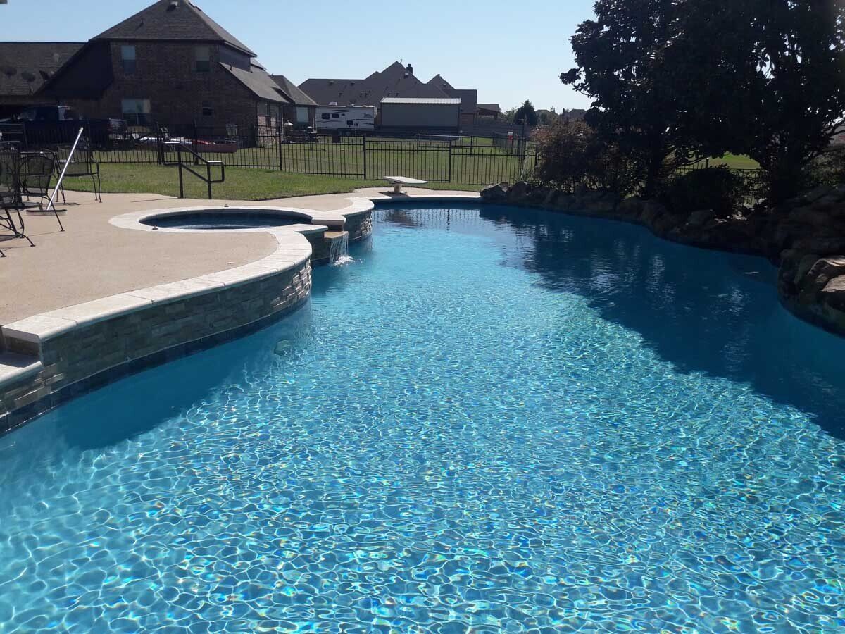A large swimming pool with a house in the background