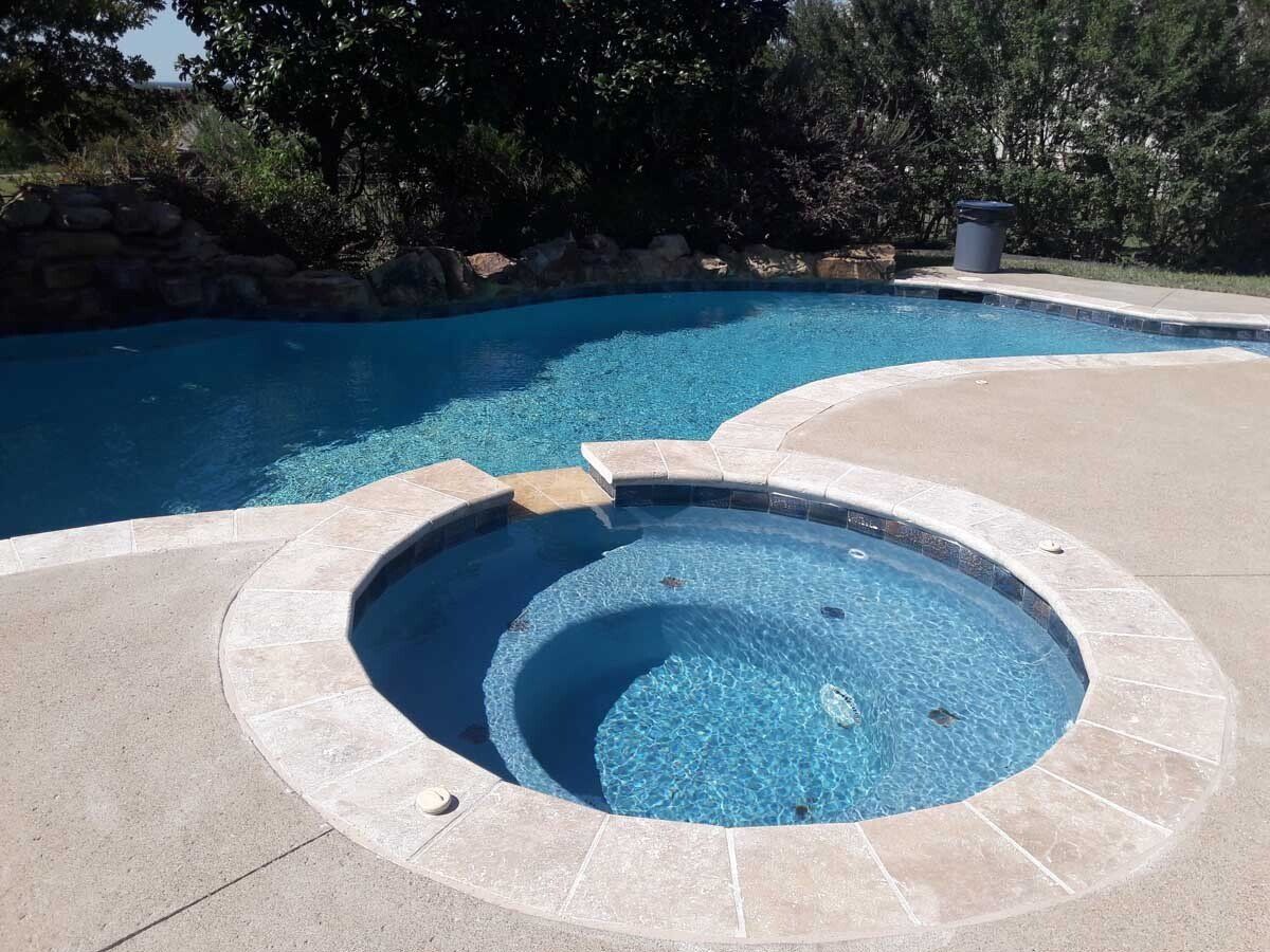 A swimming pool with a hot tub in the middle