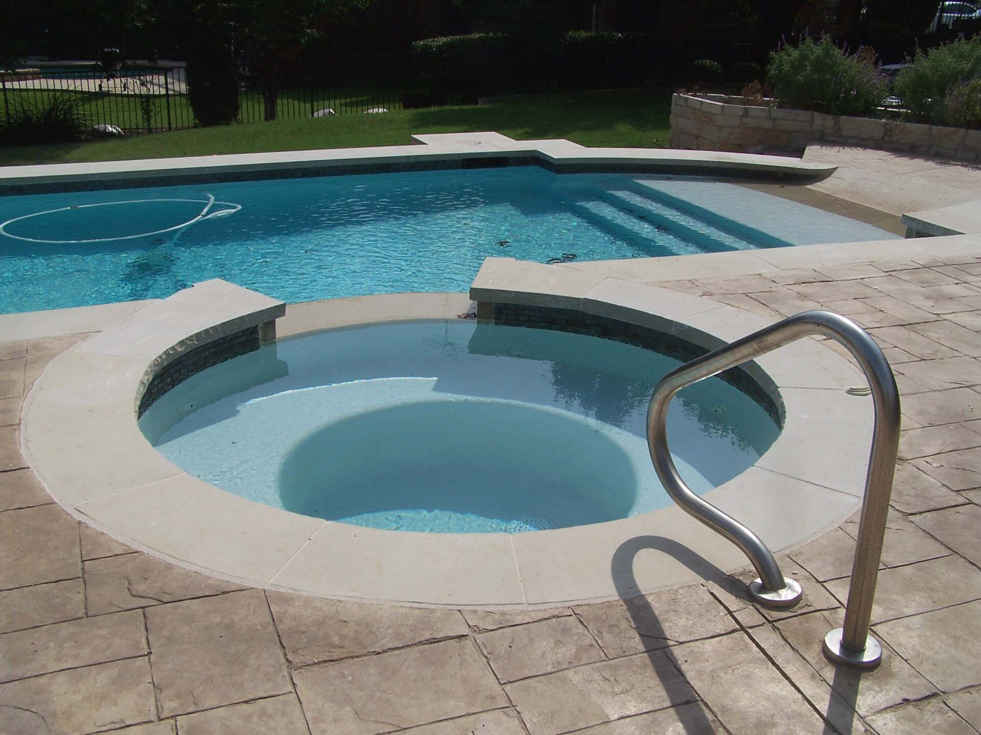 A swimming pool with a hot tub in the middle