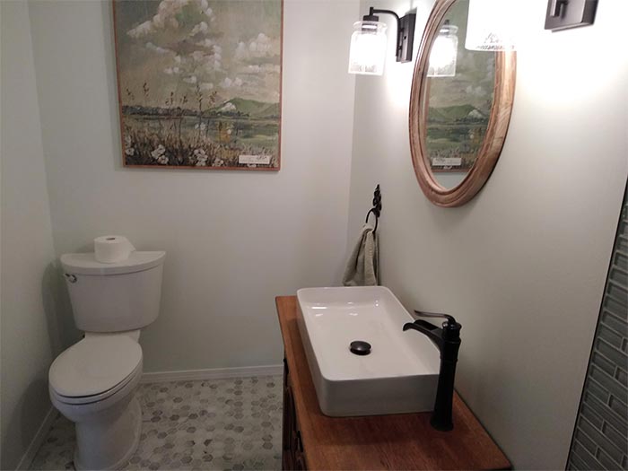 A bathroom with a toilet a sink and a mirror