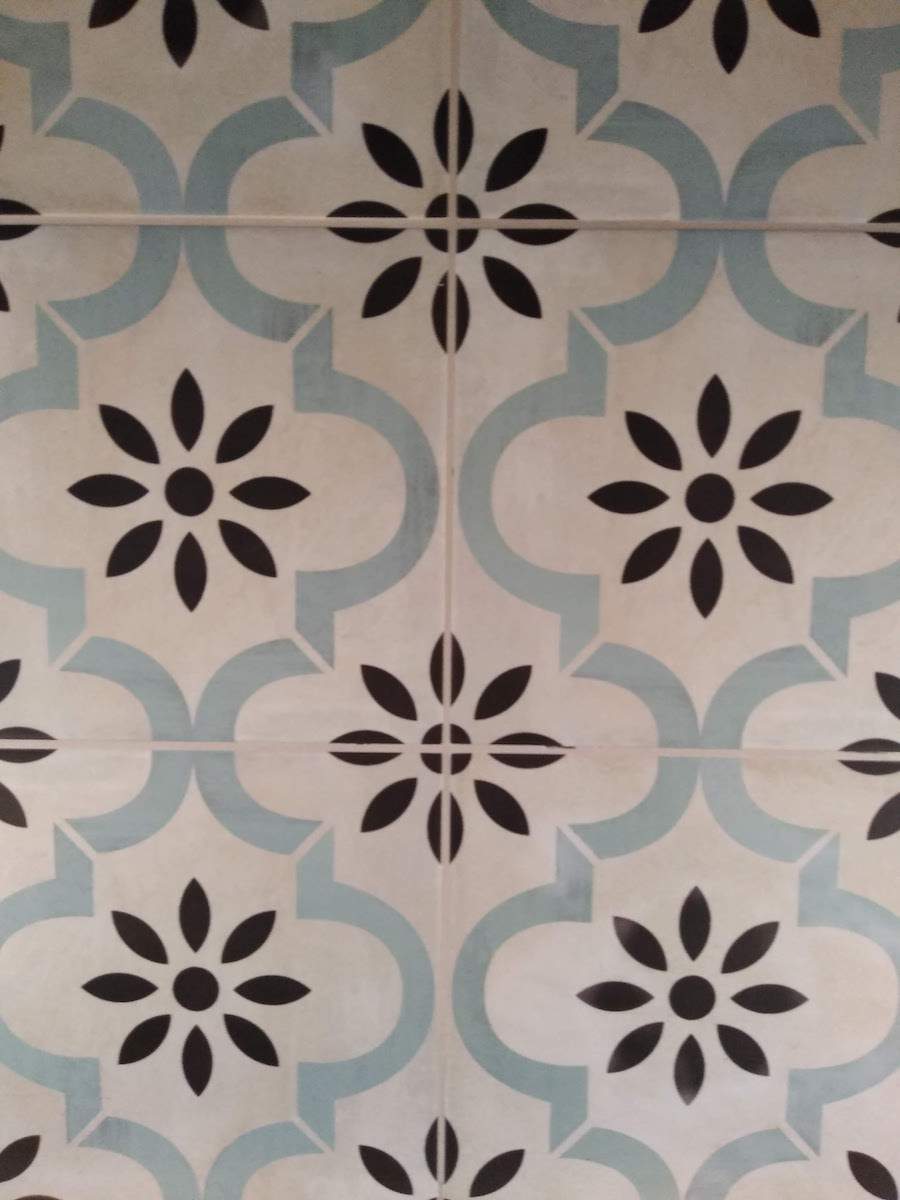 A white tile with black flowers on it