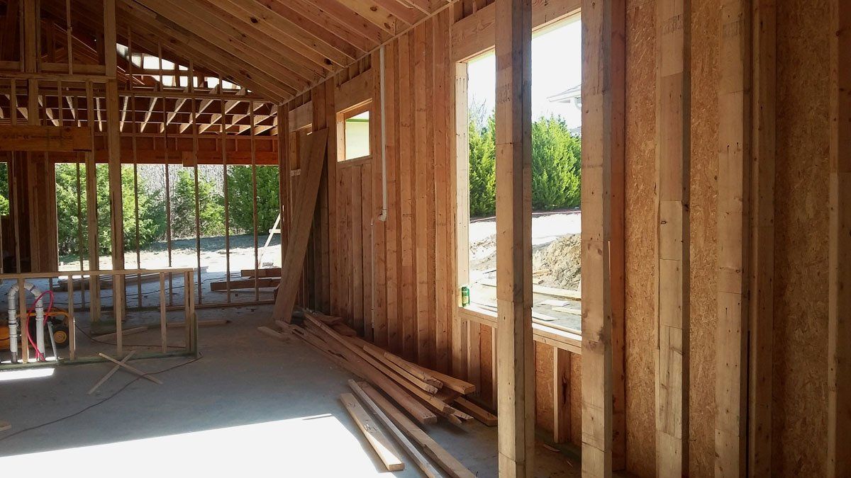 A house is being built with wooden beams and windows.